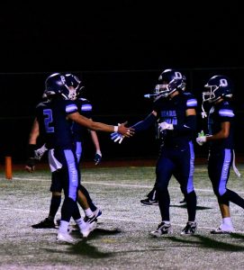 Quarterback Cameron Downing and wide receiver Harper Hejtmanek high five'ing after a touchdown.