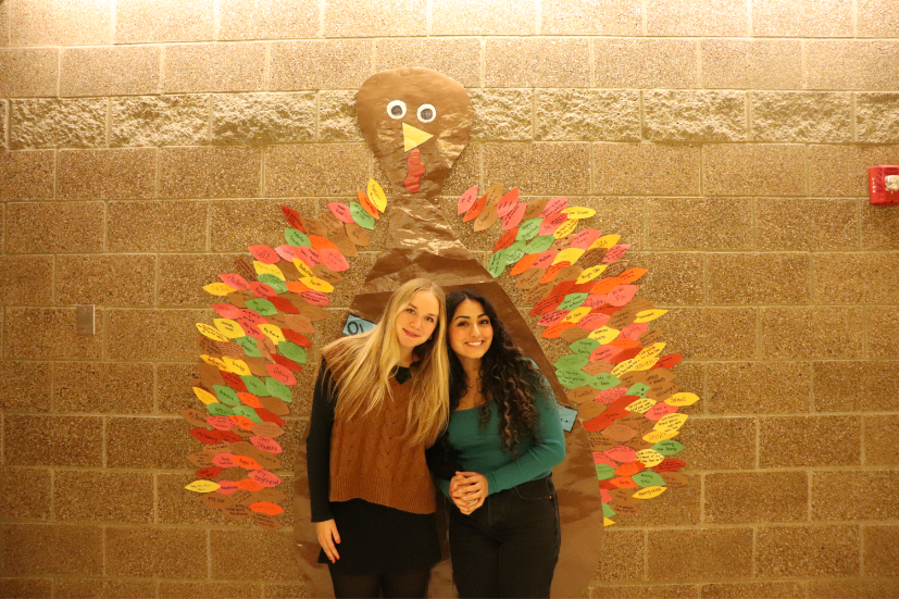 Olympia High School seniors Natalie Bowers and Jenna Rafeh spread Thanksgiving cheer in their festive attire, posing with the ‘Gratiturkey’ in the main hall. Thanksgiving is a holiday tradition filled with gratitude and fun! 