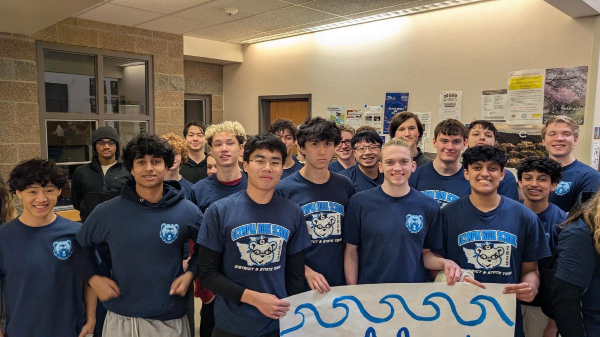 Photo by Lucas Gallardo. The swimming team with its captains and senior swimmers, showcasing their team shirts, still at OHS before the state competition.